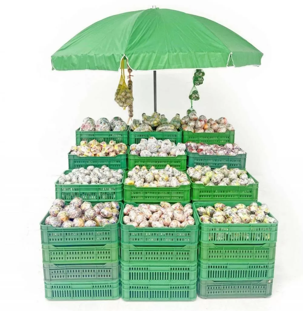 Adriana Martínez Barón (Bogotá, 1988) Tutti Frutti Market 2017. Instalación. Frutas decorativas cubiertas con calcomanías, canastos de plástico, mallas y sombrilla Dimensiones variables