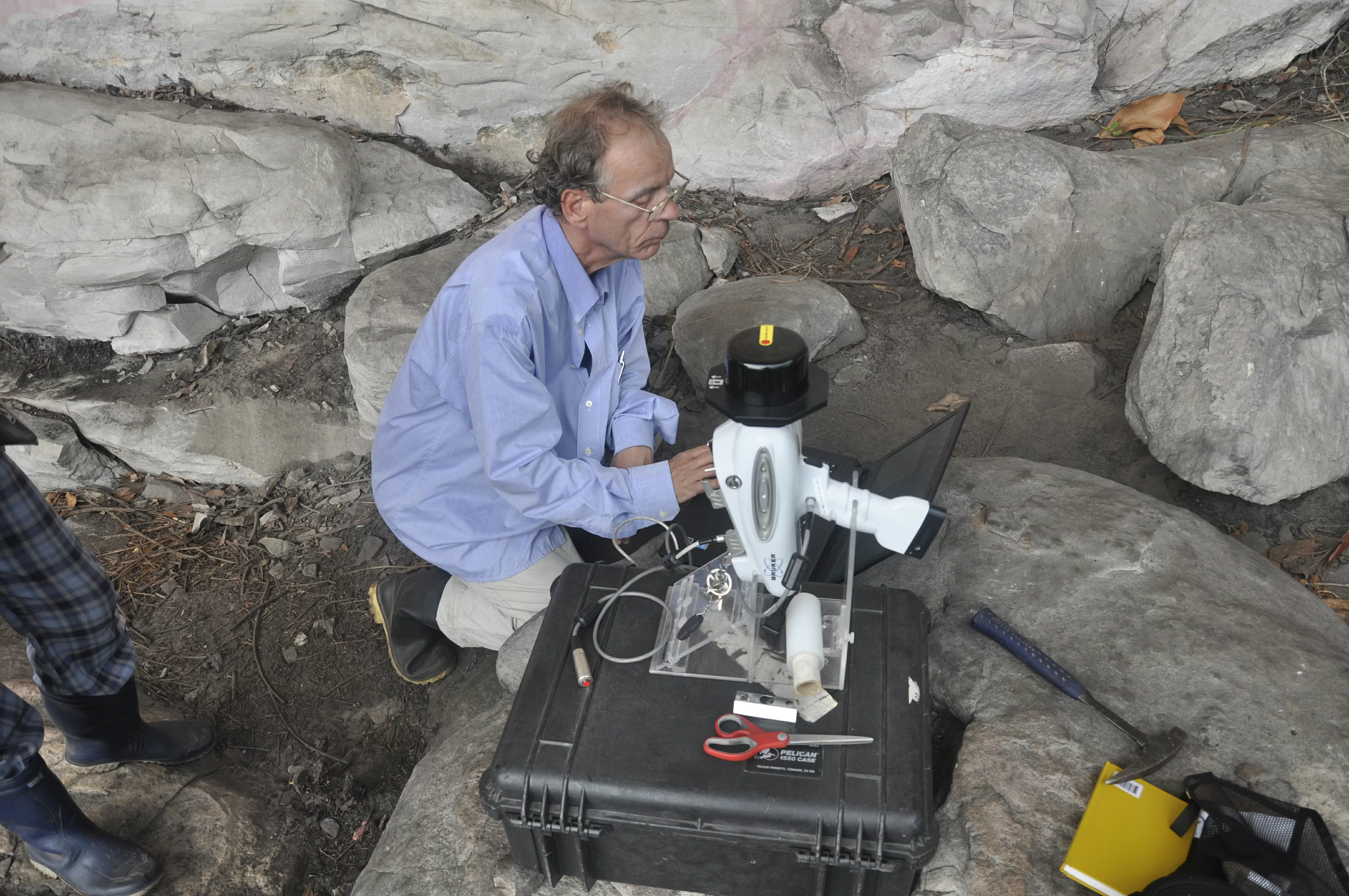 Geólogo investigando un sitio con pintura rupestre Geólogo investigando un sitio con pintura rupestre