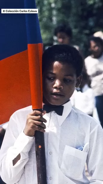 Niño sosteniendo una bandera de Colombia.