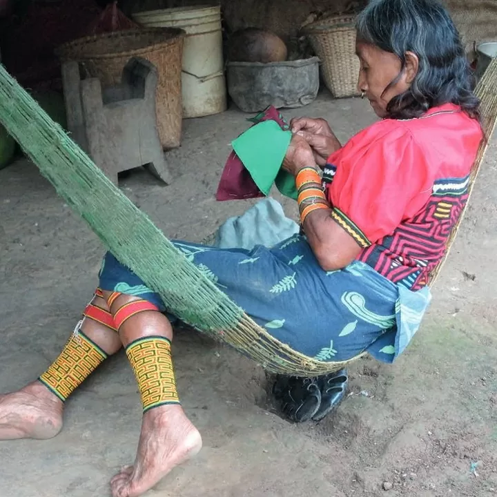 Fotografía de una mujer nele dentro de la comunidad gunadule elaborando una mola