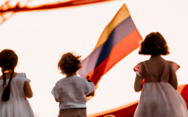 Niños observando la bandera de Colombia