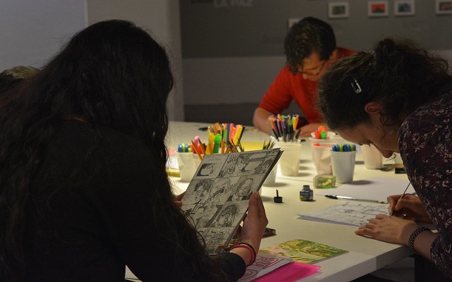 3 jóvenes sentados leyendo y pintando comic 