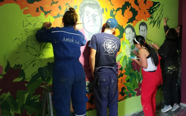 Participantes del laboratorio de mural Otras comunidades imaginadas, pintando.