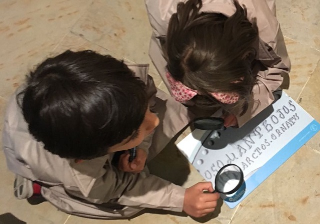 niños observando mediante una lupa