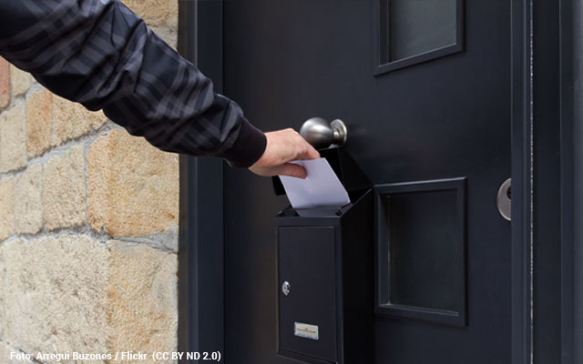 Persona introduciendo una carta en un buzón