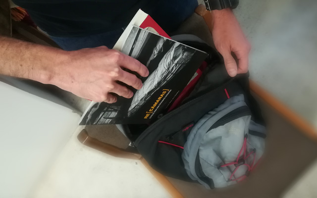 detalle de un morral en el que se están guardando libros