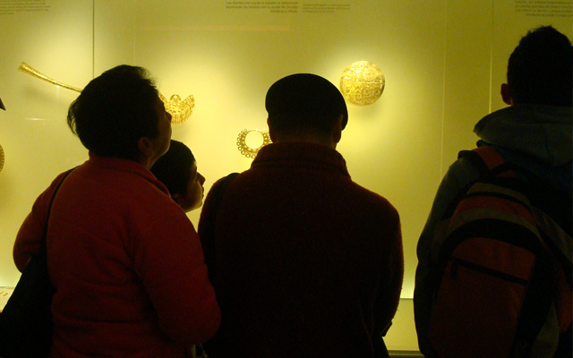 Grupo de visitantes frentea una vitrina del museo del oro